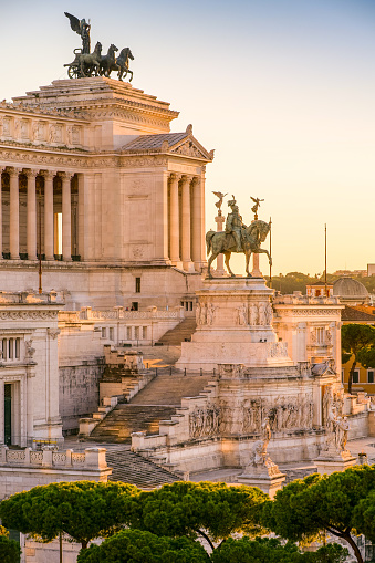 A stunning sunset light envelops the National Monument of the Altare della Patria, in the historic heart of Rome. The Altare della Patria, or Vittoriano, was built in 1885 in neoclassical style in honor of the first King of Italy, Vittorio Emanuele II (bronze equestrian statue in the center) near the Roman Forum, between the north side of the Capitoline Hill (Campidoglio) and the central Piazza Venezia. Inside is the Tomb of the Unknown Soldier, a War Memorial dedicated to all the Italian soldiers who died in the war. The Altare della Patria is the scene of all the official Italian civic celebrations, in particular the Republic Day on June 2 and the Liberation Day on April 25. In 1980 the historic center of Rome was declared a World Heritage Site by Unesco. Image in high definition format.