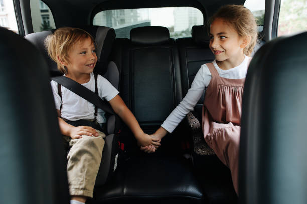 istock Two loving siblings sitting on a back seat of a car, holding hands 1338704122