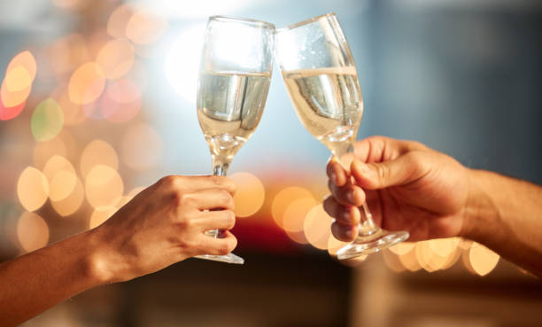 istock Shot of two unrecognizable people having champagne during a celebration 1338704421