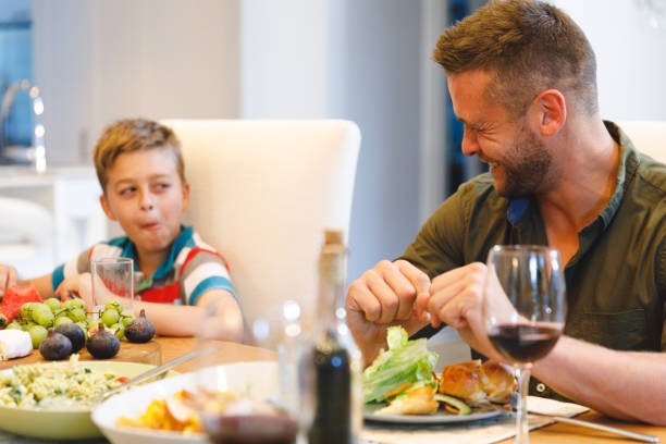 istock Happy caucasian father with son sitting at table and having dinner 1338704721