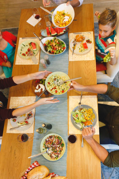 istock Overhead view of caucasian parents with son and daughter sitting at table and having dinner 1338705607