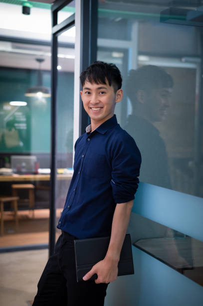 istock Smiling male business executive with digital tablet in modern office 1338705719