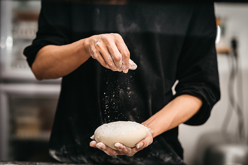 Hands knead the dough (powder) for pizza making