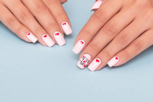 istock Female hands with romantic manicure nails, hearts design 1338708815