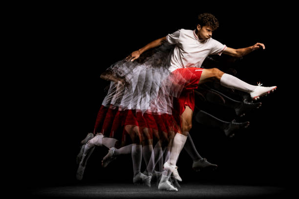 istock Stroboscope effect. Professional football player isolated on black background playing 1338709133