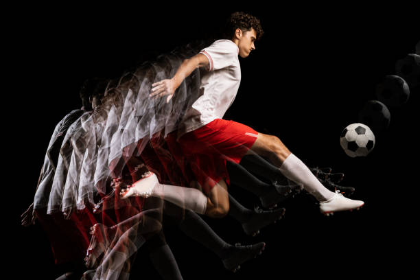 istock Young professional football player isolated on black background playing. Stroboscope effect. 1338709145