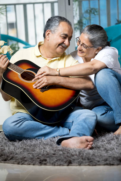 istock Couple having fun playing guitar at home 1338711393