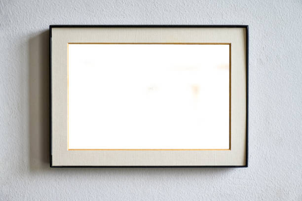istock Blank photo frame hanging on white wall in daylight 1338711739