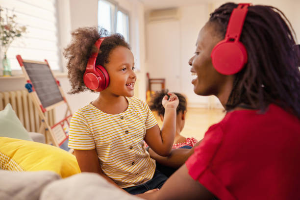 zabawna afroamerykańska matka i córka słuchające razem muzyki w domu - mothers audio zdjęcia i obrazy z banku zdjęć