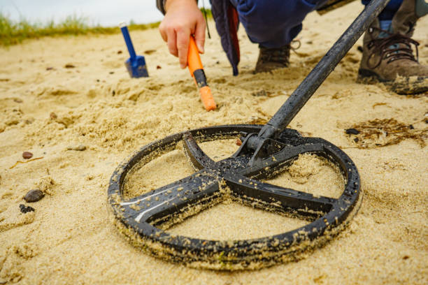 istock Man with metal detector on sea beach 1338714612