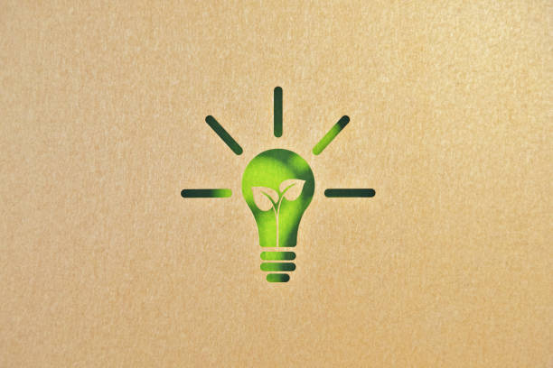 concetto di sostenibilità ed energia rinnovabile - ritaglia la forma della lampadina in carta riciclata su sfondo verde - recycled bulb foto e immagini stock