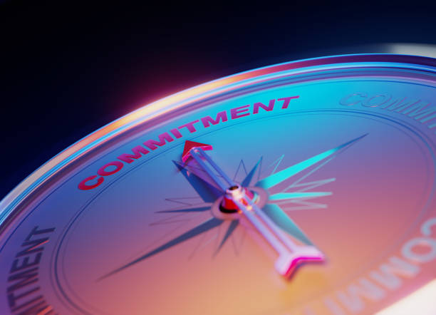 istock Commitment Concept: Arrow of The Compass Pointing The Commitment Word Over Dark Blue Background 1338716639