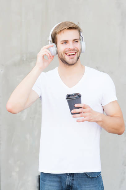 pule a pista. o consumo de café o deixa mais feliz. homem bonito bebe café para ir xícara de papel. conceito de café. café. o cara gosta de café fresco e quente. quantidade diária de cafeína. caminhando com música - fresh coffee audio - fotografias e filmes do acervo