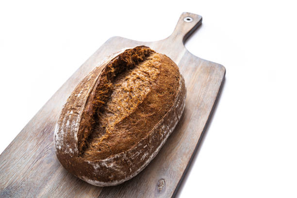 Sourdough bread brown wholegrain with rye and wheat flour homemade German style on cutting board isolated on white