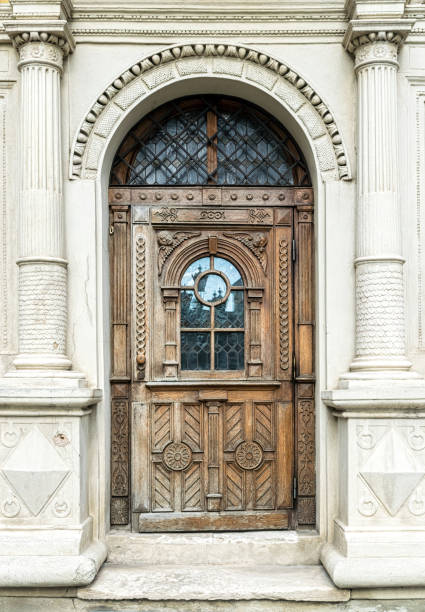 Old wooden door of a house in the historic quarter of the city. Background and texture of carved brown polished wood