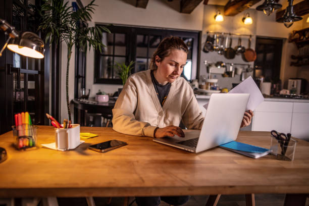 istock Young woman working on a laptop at home 1338718263