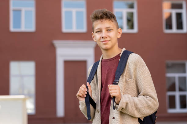 istock Contemporary youngster with backpack standing against building exterior 1338720181
