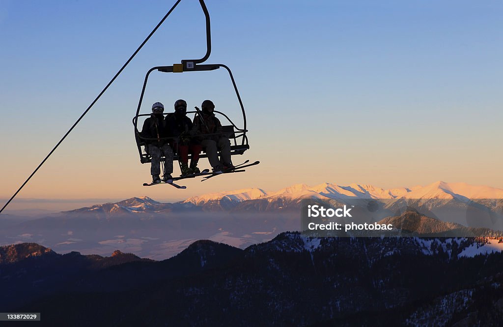 Cadeira com esquiadores no teleférico de esqui pôr-do-sol - Foto de stock de Teleférico - Meio de Transporte royalty-free