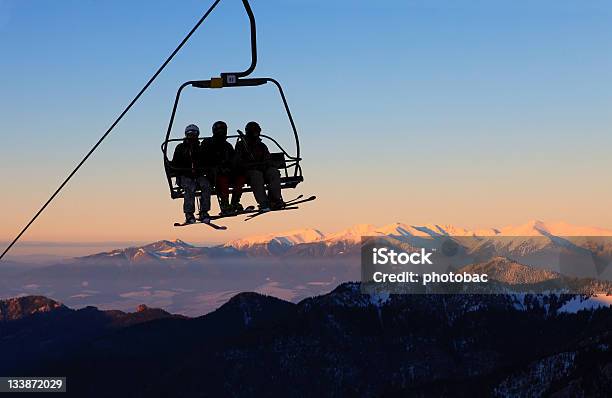 Foto de Cadeira Com Esquiadores No Teleférico De Esqui Pôrdosol e mais fotos de stock de Teleférico - Meio de Transporte