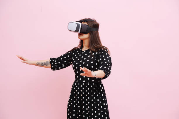 istock Funny woman in VR headset probing space around her with her hands. 1338727349
