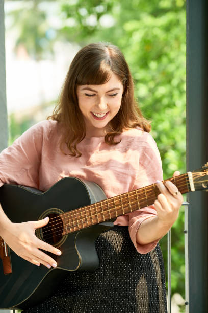 istock Woman Enjoying Playing Guitar 1338728012