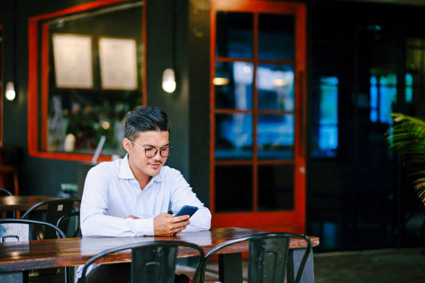 istock Portrait of Senior Executive Man Using Mobile Phone While Sitting at Cafe 1338728250