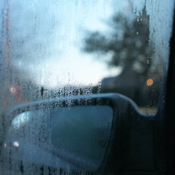 Stock photo showing condensation on steamed up passenger car window causing poor visibility in wing mirror.