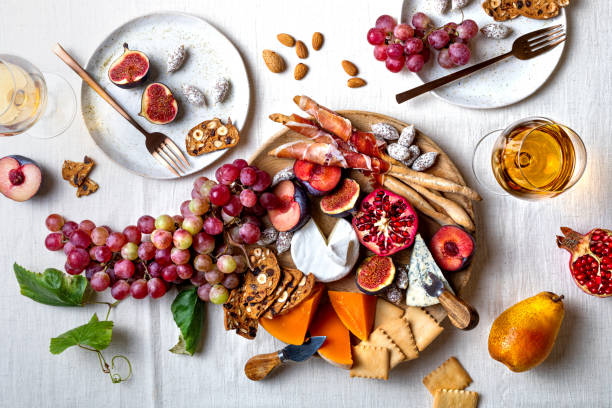 vorspeisentisch mit italienischen antipasti-snacks oder authentischen traditionellen spanischen tapas. herbst obst, käse und fleisch sortenbrett. blick auf die oberseite, flach liegen - brettchen stock-fotos und bilder