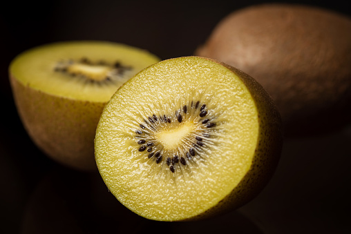 Yellow kiwi fruits on on dark background closeup