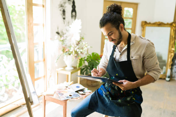 istock Creative man drawing in front of a canvas 1338735302