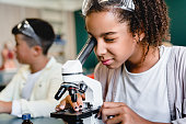 istock African-american schoolgirl pupil student using working with microscope at biology chemistry lesson class at school lab. Science lesson concept 1338737384