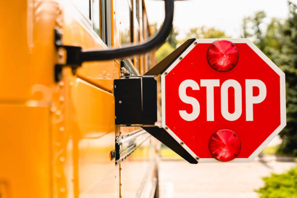 Close up yellow school bus. Stop sign. Be careful, schoolchildren crossing the road. New academic year semester. Welcome back to school. Lockdown, distance remote education learning stock photo