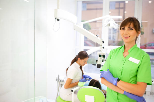 istock Dentist looks through a microscope to treat tooth canals. 1338737508