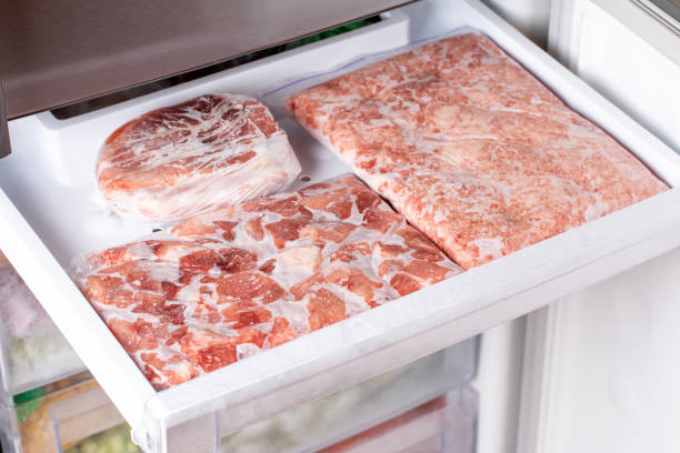 istock Frozen meat in plastic package in the freezer. 1338737912