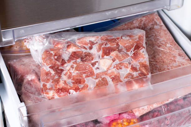 istock Raw frozen meat. Raw pork chops in the freezer. 1338737919