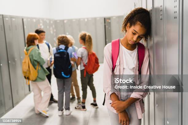Lonely Sad Africanamerican Schoolgirl Crying While All Her Classmates Ignoring Her Social Exclusion Problem Bullying At School Concept Racism Problem Stock Photo - Download Image Now