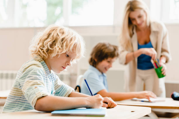 istock Drawing lesson. Funny interesting class with teacher. Pupils schoolchildren classmates students involved in learning process. Attendancy concept 1338740082