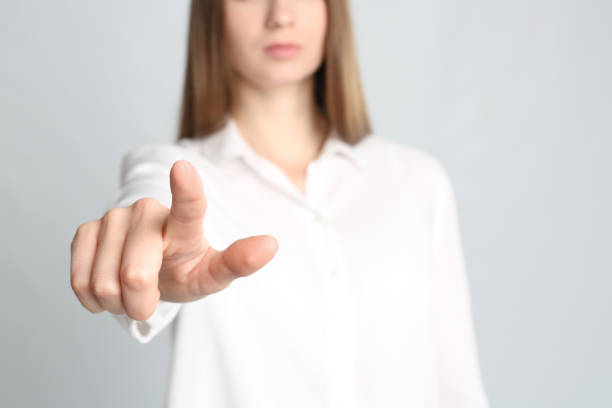 istock Young woman against light grey background, focus on hand 1338740237
