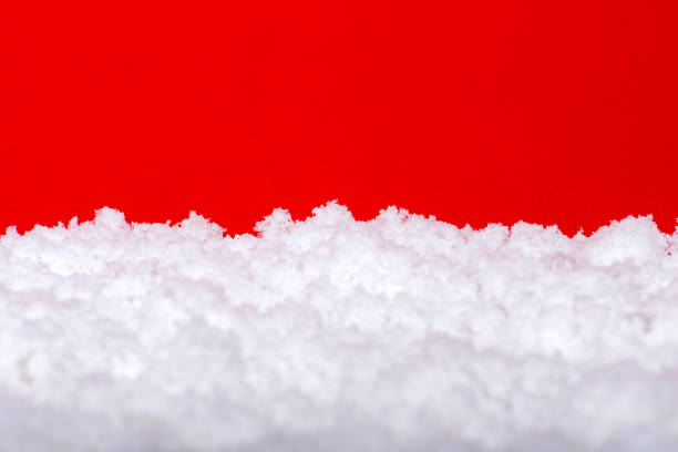 istock Snow on a red background. Christmas theme, large format, panoramic photo for a banner or website header. Christmas greeting card for printing 1338740932