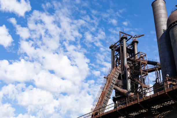 istock Rusting metal structures of an industrial site set against a brilliant blue sky with white clouds, creative copy space 1338743267