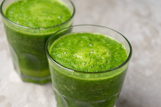istock Green juice in glass on grey background 1338744392