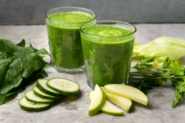 istock Green juice and ingredients in glass on grey background 1338744549