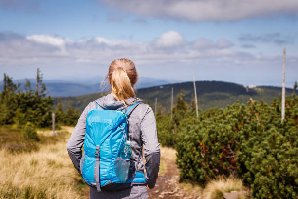 istock Woman with backpack hiking in mountains 1338745659