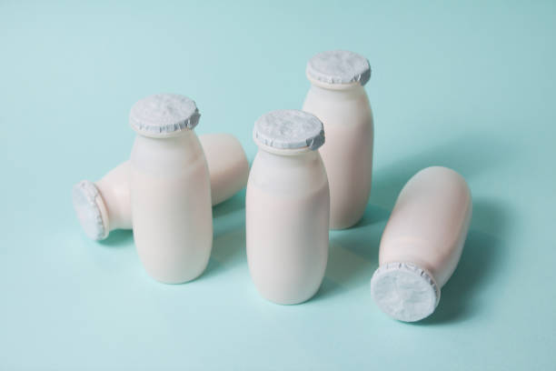 Bottles with probiotics and prebiotics dairy drink on light blue background.