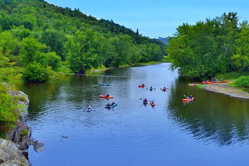 Family water activity on the Lamoille river in Cambridge, Vermont, USA - August 17,2021.  Tourist families canoe and kayak on the Lamoille river in Vermont on a late August day as summer tourist season draws to a close, the children will remember this forever