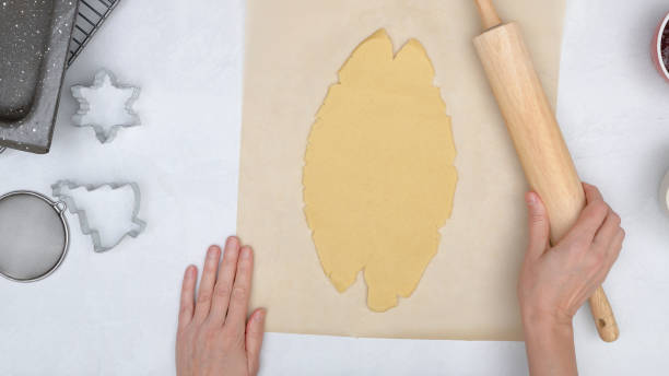 istock Christmas shortbread cookies with raspberry jam recipe. Chef rolls cookie dough on kitchen table, view directly from above 1338746135