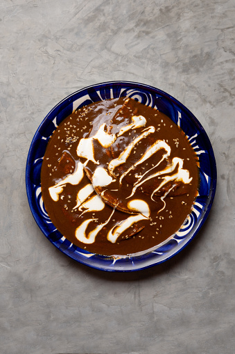Traditional mexican food. Enchiladas with mole sauce also called Enmoladas on grey background