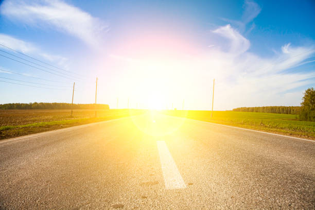 Road and bright sun. Summer landscape. Path to a brighter future.
