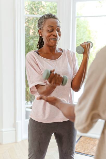 istock Fit senior woman doing workout with weights at home 1338748908