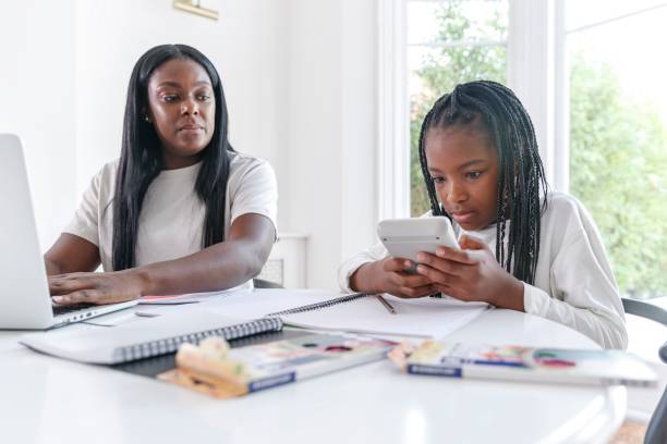 istock Mother working from home as elementary age daughter does distance learning homework 1338748919